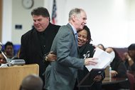 Cook County Circuit Judge Charles P. Burns (center) celebrates with Ledore Lenoir (right) as she receives her certificate for completing her treatment program and graduating from Cook County Drug Court. Lenoir was among 24 people who graduated from Cook County Drug Court Thursday at the Leighton Criminal Court Building.