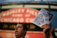 Vendor Matthew Smerge holds a copy of Chicago Baseball magazine outside Wrigley Field before Game 3 of the National League baseball championship series between the New York Mets and the Chicago Cubs on Oct. 20, 2015. 