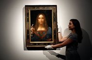 An employee poses with Leonardo da Vinci’s “Salvator Mundi” on display at Christie’s auction rooms in London in October. The rare painting of Christ, which sold for a record $450 million, is heading to a museum in Abu Dhabi. The newly-opened Louvre Abu Dhabi made the announcement in a tweet on Wednesday. 