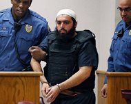 Ahmad Khan Rahimi, the man accused of setting off bombs in New Jersey and New York in September, is led into court in Elizabeth, N.J., in this December photo. Prosecutors said the case against Rahimi relies on video from security cameras in storefronts and businesses all over New Jersey and New York. 