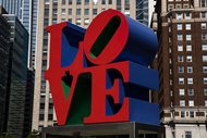The Robert Indiana sculpture “LOVE” in Philadelphia’s John F. Kennedy Plaza. Indiana, best known for his 1960s “LOVE” series, died in May at 89 years old. Maine court proceedings over Indiana’s estate will be held up over a lawsuit alleging his caretaker and an art publisher took advantage of him and produced forgeries.