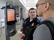 U.S. Customs and Border Protection supervisor Erik Gordon helps a passenger navigate one of the new facial recognition kiosks at a United Airlines gate before boarding a flight to Tokyo, Wednesday at George Bush Intercontinental Airport in Houston. The Trump administration intends to require that American citizens boarding international flights submit to face scans, something Congress has not explicitly approved and privacy advocates consider an ill-advised step toward a surveillance state. 