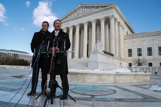 Louisiana Attorney General Jeff Landry, who opposes mandates, speaks outside the Supreme Court after arguments about vaccine-or-testing requirements on Friday in Washington with deputy Louisiana Attorney General Bill Stiles. On Thursday, the Court halted a rule applying to large employers but allowed another to stand for most health care workers.