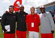 Lawyer and sports agent Matthew F. Smith (second from right) stands with his father and client, Tampa Bay Buccaneers head coach Lovie Smith (second from left). Also pictured are Bucs intern Miles Smith, Matthew’s younger brother; and his older brother, Mikal Smith, a safeties coach for the team. 