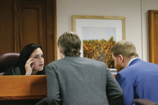 Judge Maya Guerra Gamble speaks with Andino Reynal, left, lawyer for Alex Jones, and Mark Bankston, lawyer for two Sandy Hook parents, at the Travis County Courthouse last week. A Texas jury on Friday ordered Jones to pay $45.2 million in punitive damages, adding to $4.1 million in compensatory damages awarded earlier.