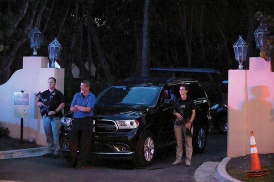 Armed Secret Service agents stand outside an entrance to former President Donald Trump's Mar-a-Lago estate late Monday in Palm Beach, Fla. Trump said in a lengthy statement that the FBI was conducting a search of the estate and asserted that agents had broken open a safe.