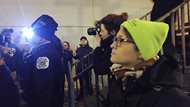Sharlyn D. Grace (forefront) observes anti-Trump protesters interact with Chicago police officers outside Blue Frog’s Local 22, 22 E. Hubbard St., on Friday night, hours after President Donald Trump took office. Grace serves as a neutral legal observer for the National Lawyers Guild, which monitors and records police activity during demonstrations. 