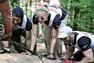 Amelia R. Boone of Skadden, Arps, Slate, Meagher & Flom LLP works with others to move a large stone up a mountain during the 2013 Summer Death Race in Vermont. Competitors had to move their stones up the side of the mountain and build a stairway. Boone, a corporate restructuring attorney, is a decorated obstacle course racing athlete who has two corporate sponsors. See more of Boone in action in this photo gallery.