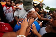 Cameron Sterling, son of Alton Sterling, is comforted by hands from the crowd at a vigil outside the Triple S convenience store in Baton Rouge, La., on Wednesday. Sterling, 37, was shot and killed by Baton Rouge police outside the store where he was selling CDs. The U.S. Department of Justice is investigating. 